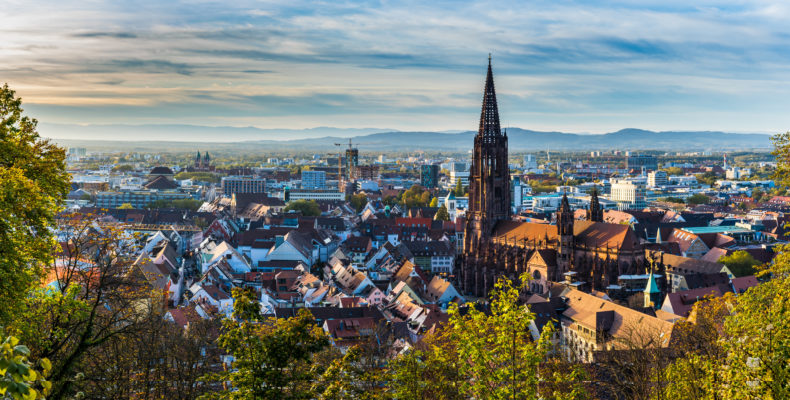 Germany, XXL panorama of city freiburg im breisgau skyline with cathedral muenster in old town in warm sunset light in romantic autumn season, aerial view above cityscape